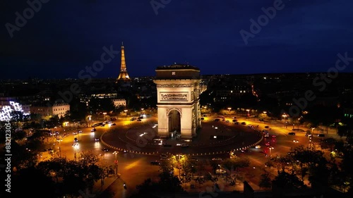 Paris, Arc de Triomphe Triumphal Arch at Chaps Elysees at night, Paris, France. Drone view, Eiffel Tower in the background.  Architecture and landmarks of Paris. Postcard of Paris
