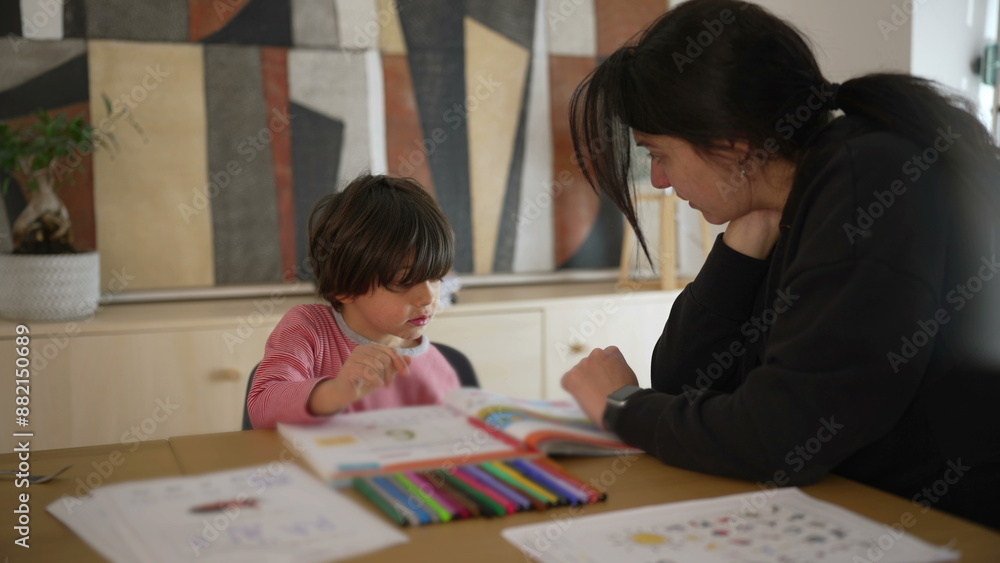 Child and parent studying together at a table, focused on a colorful workbook, highlighting the significance of educational activities and parental guidance in a home environment Child and parent studying together at a table, focused on a colorful workbook, highlighting the significance of educational activities and parental guidance in a home environment