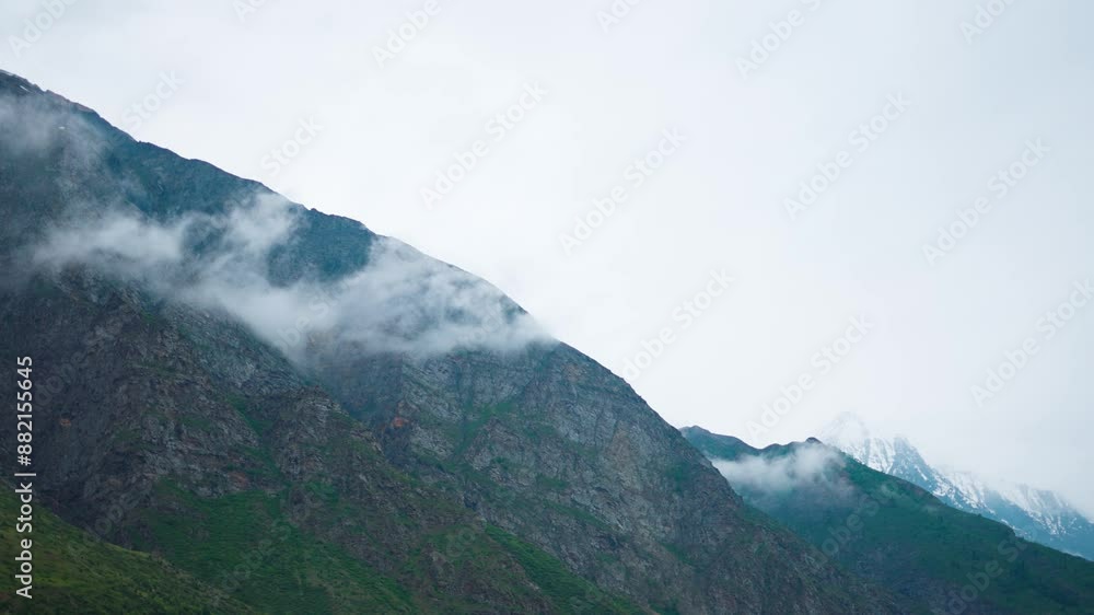 4K shot of clouds under the Himalayan mountain peaks during the monsoon season as seen from Keylong in Lahaul, Himachal Pradesh, India. Cloud under the mountain during the rainfall. Nature background. 4K shot of clouds under the Himalayan mountain peaks during the monsoon season as seen from Keylong in Lahaul, Himachal Pradesh, India. Cloud under the mountain during the rainfall. Nature background.