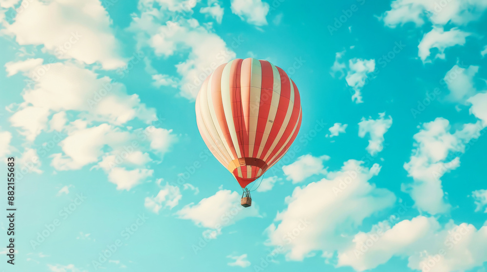 A hot air balloon floating in the sky with white clouds A hot air balloon floating in the sky with white clouds