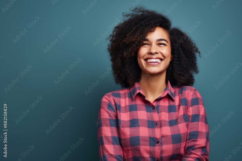 Portrait of a cheerful afro-american woman in her 30s wearing a comfy flannel shirt in front of plain cyclorama studio wall Portrait of a cheerful afro-american woman in her 30s wearing a comfy flannel shirt in front of plain cyclorama studio wall