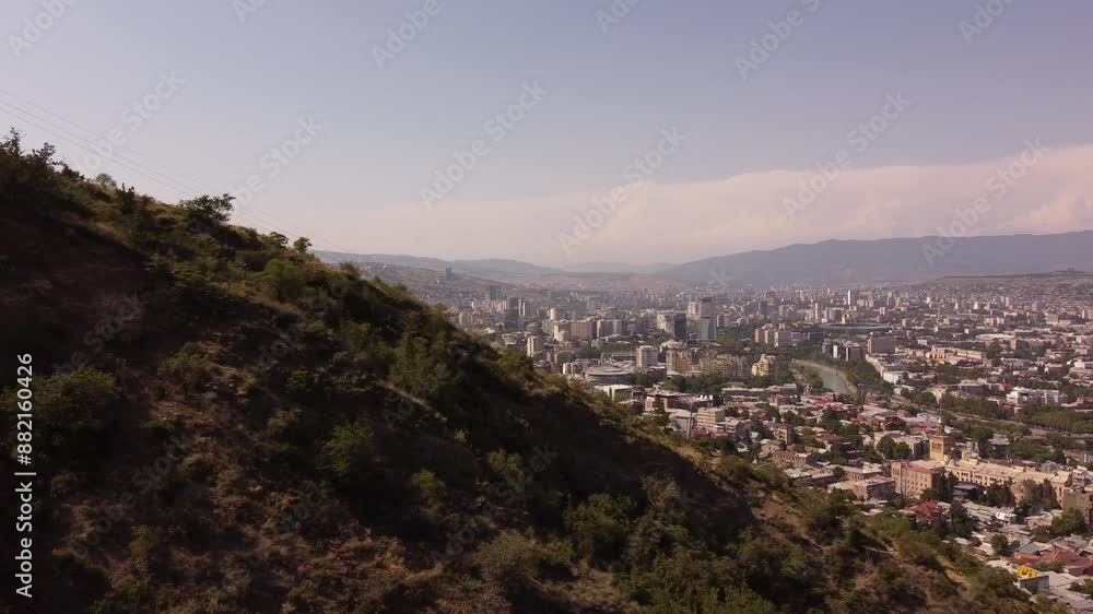 Revealing drone view of Tbilisi, Georgia, shot during summer. Old Tbilisi view from the mountains. 