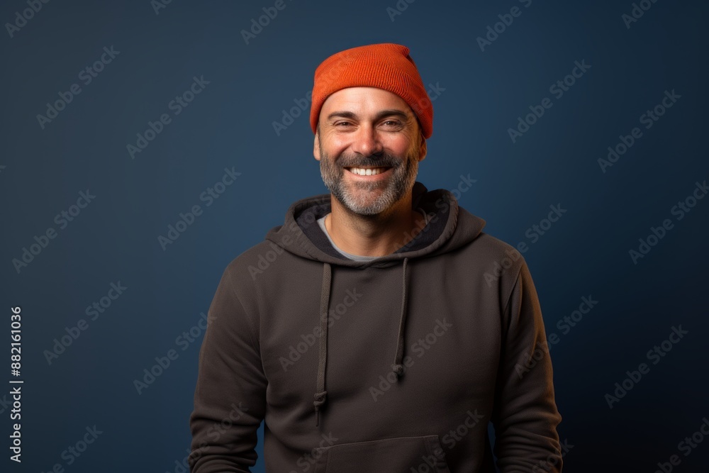 Portrait of a happy man in his 40s sporting a trendy beanie over plain cyclorama studio wall Portrait of a happy man in his 40s sporting a trendy beanie over plain cyclorama studio wall