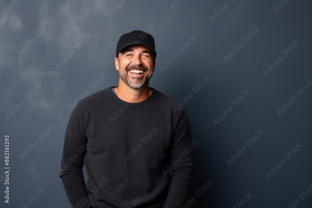 Portrait of a happy man in his 40s sporting a trendy beanie while standing against plain cyclorama studio wall Portrait of a happy man in his 40s sporting a trendy beanie while standing against plain cyclorama studio wall