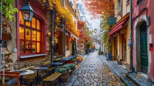 A charming European street in autumn, with cobblestone pathways and historic buildings adorned with colorful fall leaves. with outdoor seating invite passersby to sit and relax.