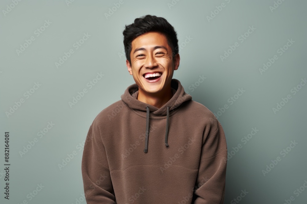 Portrait of a happy asian man in his 20s wearing a thermal fleece pullover on plain cyclorama studio wall Portrait of a happy asian man in his 20s wearing a thermal fleece pullover on plain cyclorama studio wall