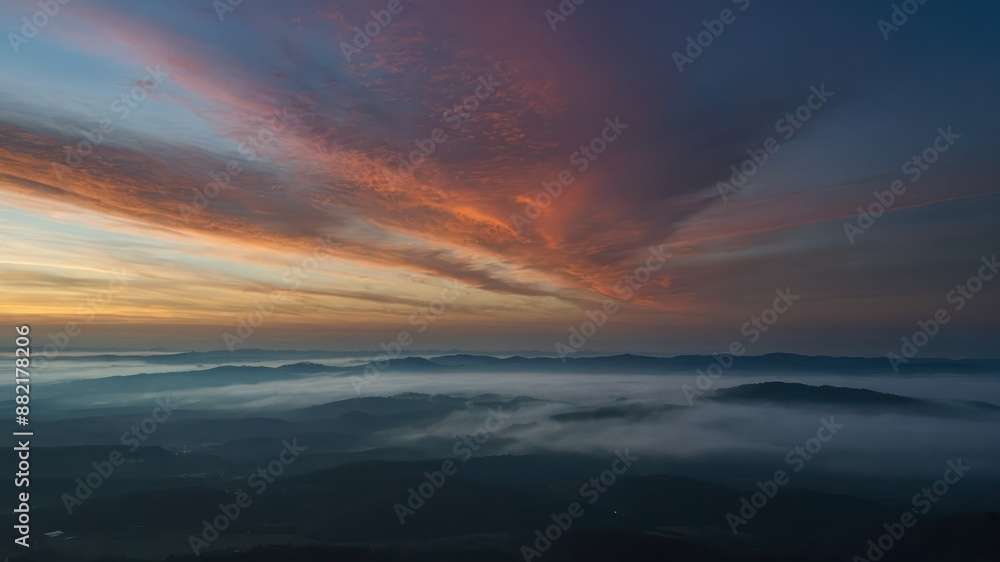 Obraz premium A breathtaking image of a dramatic sunrise over misty mountains, capturing the serene beauty and tranquility of the early morning sky and nature