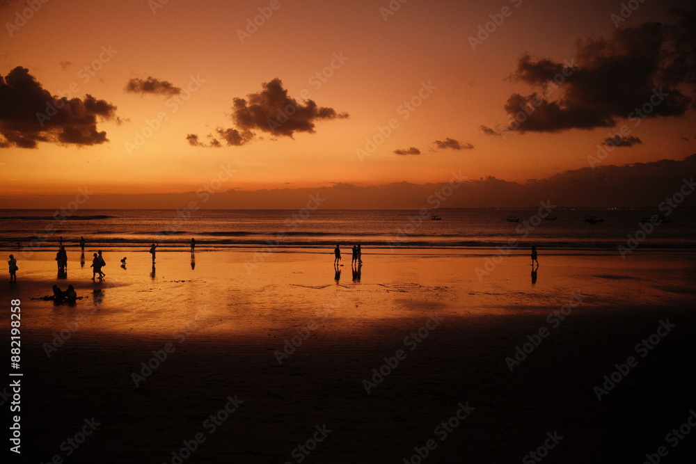 Kuta, Bali, Indonesia - July 12, 2024 : Silhouette view of the sunset reflection on the beach Kuta, Bali, Indonesia - July 12, 2024 : Silhouette view of the sunset reflection on the beach