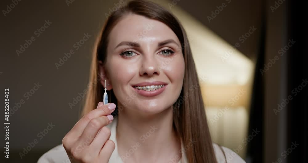 Close-up of young woman holding orthodontic brush used for cleaning braces. Focus on oral hygiene and health care. Concept of maintaining dental braces with proper tools. Dental Braces. Close-up of young woman holding orthodontic brush used for cleaning braces. Focus on oral hygiene and health care. Concept of maintaining dental braces with proper tools. Dental Braces.