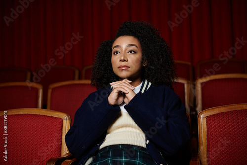 Fotografie A young woman watches a movie in a theater, captivated by the story unfolding on screen