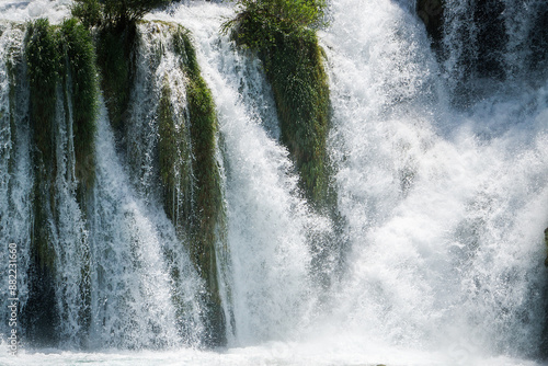 Waterfall among the green summer forest.