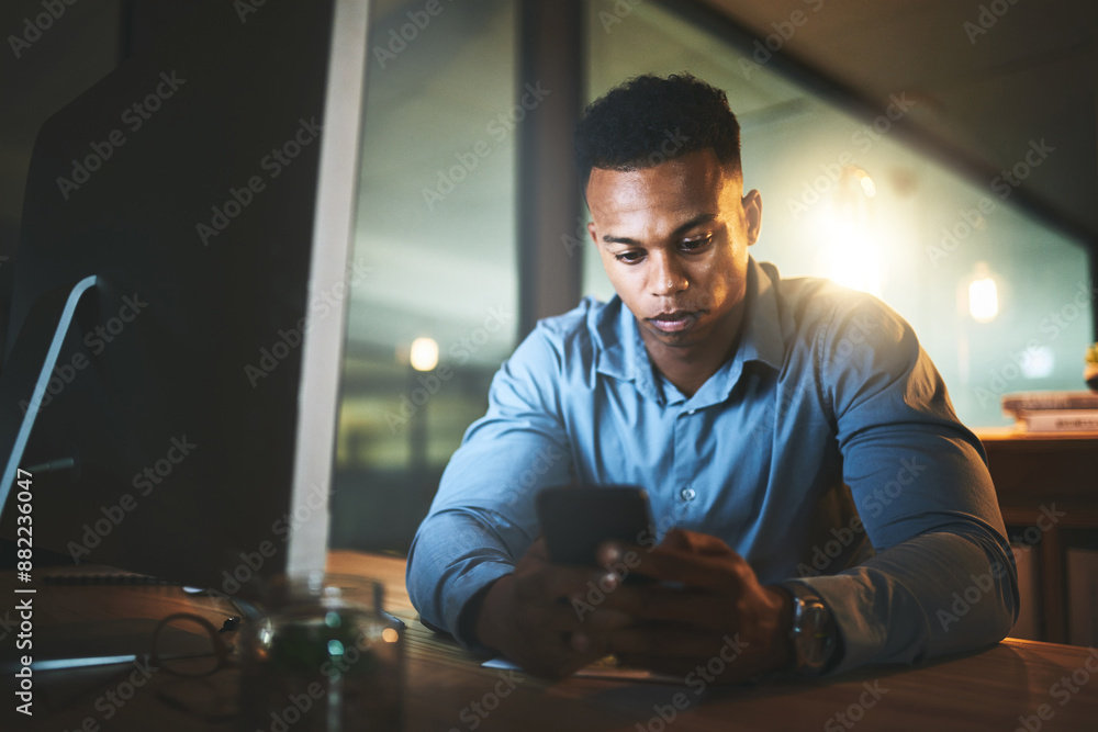 Night, search and black man at computer with phone, connection and business website at tech startup. Dark, office and businessman at desk with smartphone, networking and typing at digital agency. Night, search and black man at computer with phone, connection and business website at tech startup. Dark, office and businessman at desk with smartphone, networking and typing at digital agency.