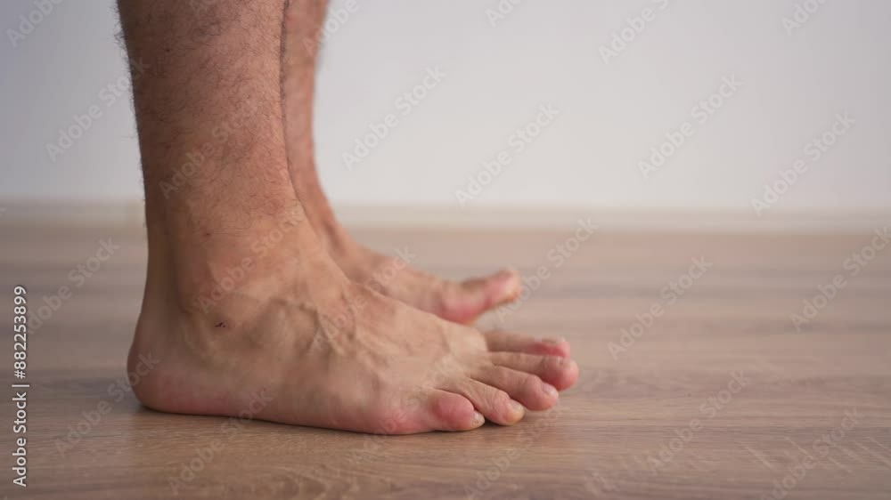 Close-up of Male Legs Doing Special Exercises to Treat Flat Feet. Concept of Therapeutic Physical Culture. Foot Health. Close-up of Male Legs Doing Special Exercises to Treat Flat Feet. Concept of Therapeutic Physical Culture. Foot Health.