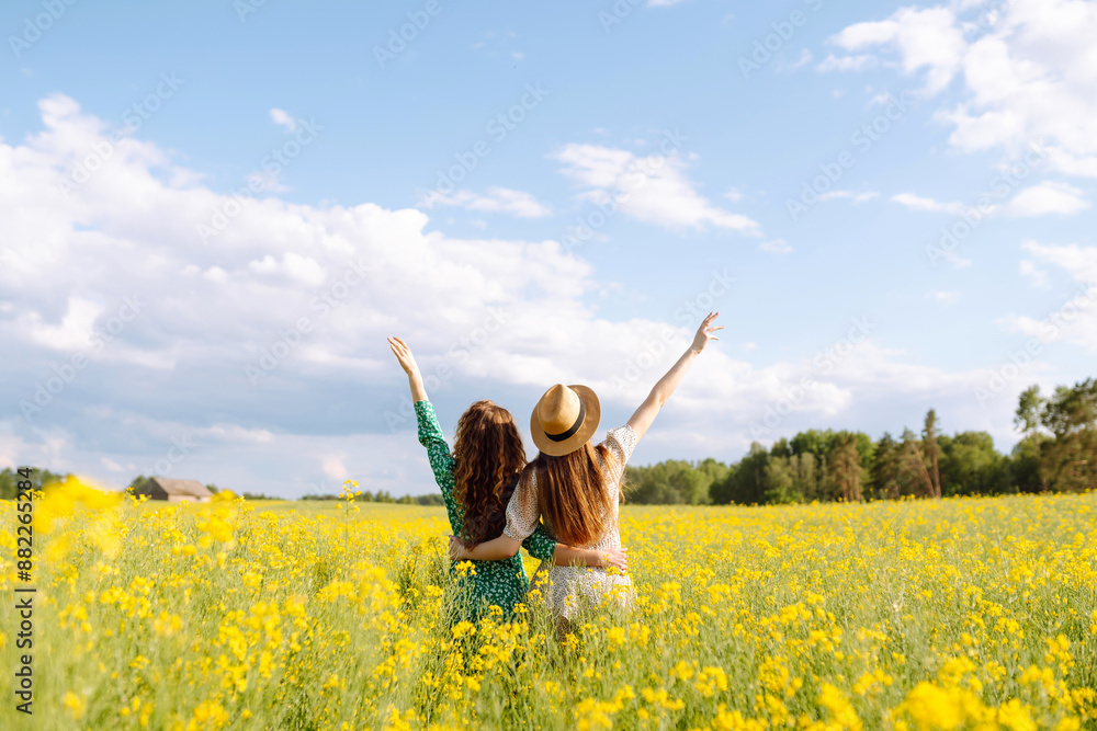 Attractive two woman in the blooming field. Nature, vacation, relax and lifestyle. Summer landscape. Attractive two woman in the blooming field. Nature, vacation, relax and lifestyle. Summer landscape.