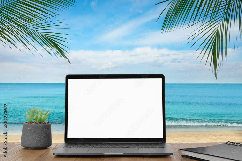 Workplace at beach, distant office. Table with laptop on sandy seashore. Mockup for design Workplace at beach, distant office. Table with laptop on sandy seashore. Mockup for design