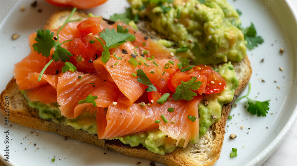 Guacamole toasts with red fish meat and greens on white plate Guacamole toasts with red fish meat and greens on white plate