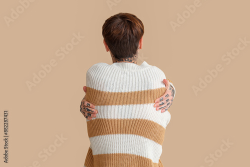 Young man hugging himself o...