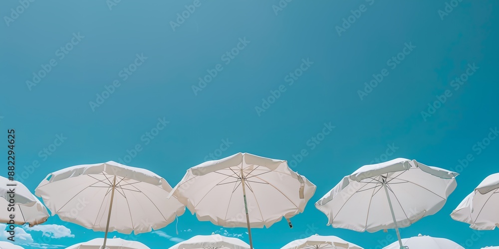 A row of white umbrellas are spread out in the sky, creating a sense of openness and freedom A row of white umbrellas are spread out in the sky, creating a sense of openness and freedom