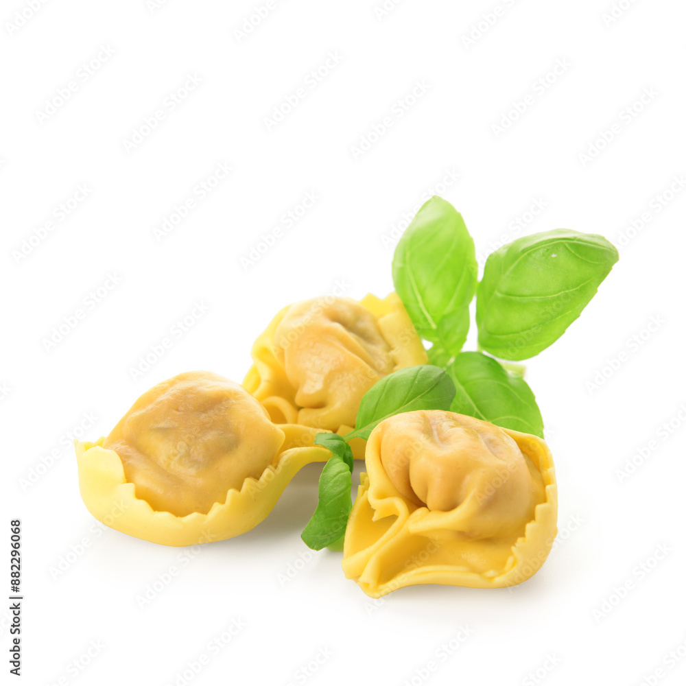 Raw dumplings and basil on white background Raw dumplings and basil on white background