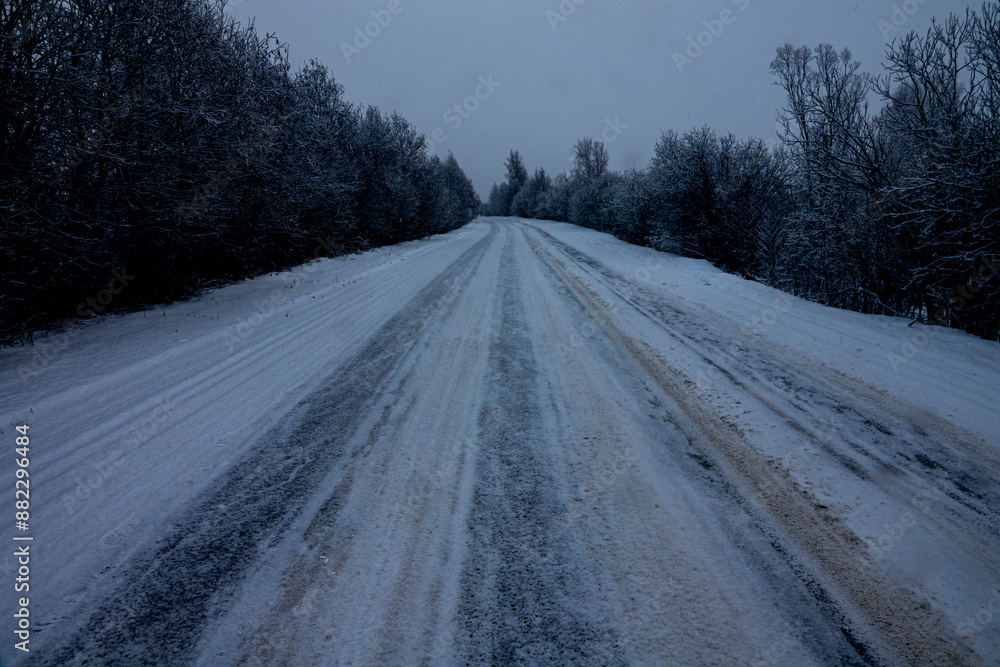 Winter highway The snow has not been removed from the secondary road after the snowfall. Cars have broken through the track, but it is dangerous because vehicle breaking away Winter highway The snow has not been removed from the secondary road after the snowfall. Cars have broken through the track, but it is dangerous because vehicle breaking away