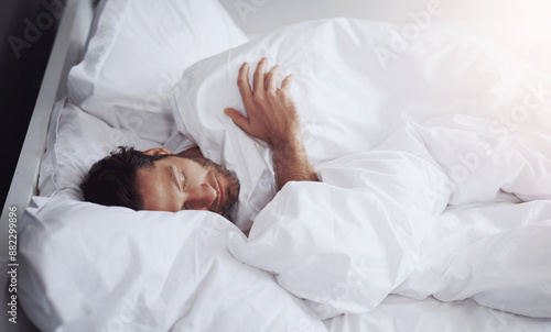 Sleeping, tired and man in bed in home for relaxing on weekend morning with dreaming in rem. Fatigue, snooze and male person with pillow and blanket for resting afternoon nap in bedroom at apartment.