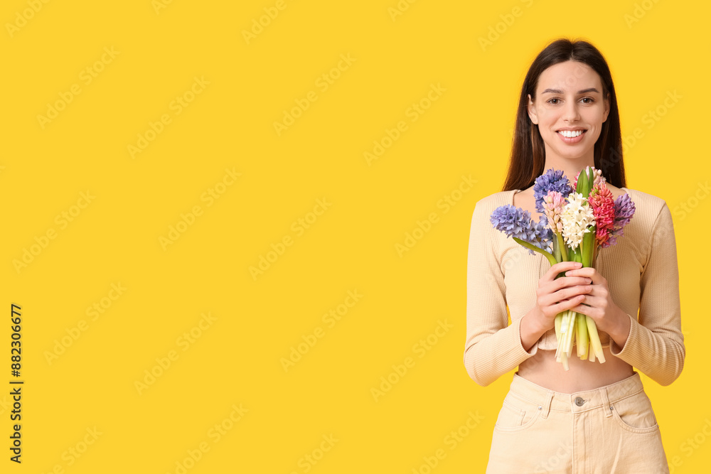 Happy smiling young woman with hyacinth flowers on yellow background Happy smiling young woman with hyacinth flowers on yellow background