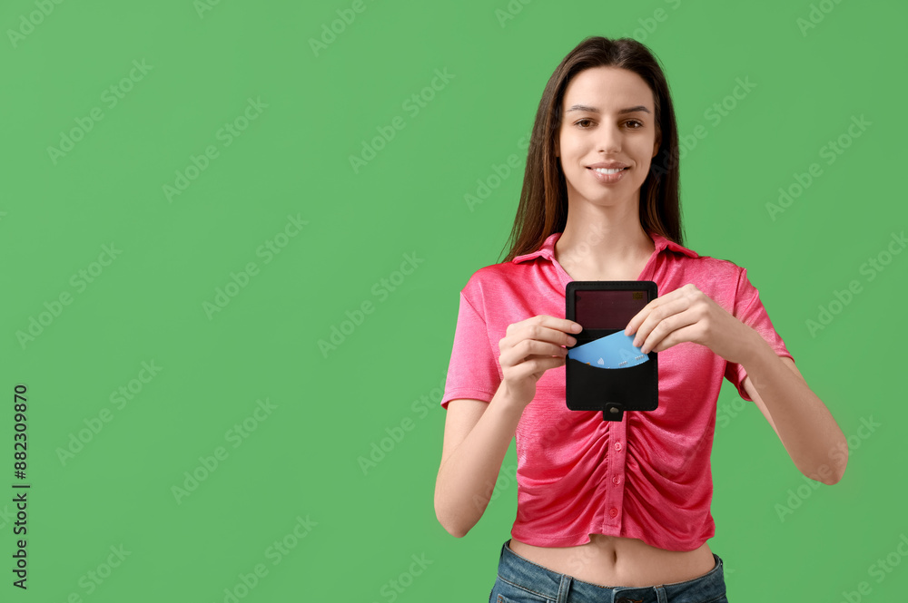 Beautiful young woman with credit card holder on green background Beautiful young woman with credit card holder on green background