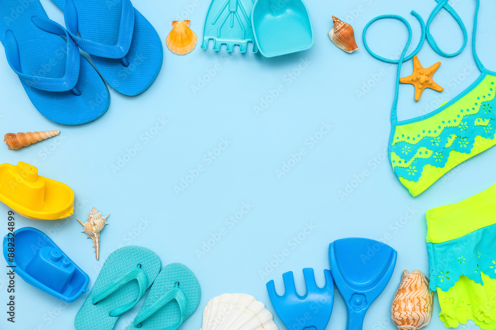 Frame made of beach accessories for children on blue background Frame made of beach accessories for children on blue background