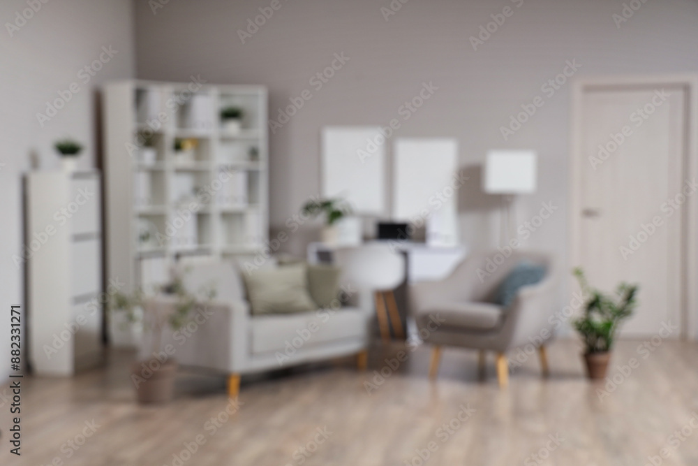 Fototapeta premium Blurred view of adolescent psychologist's office with sofa, armchair and plants