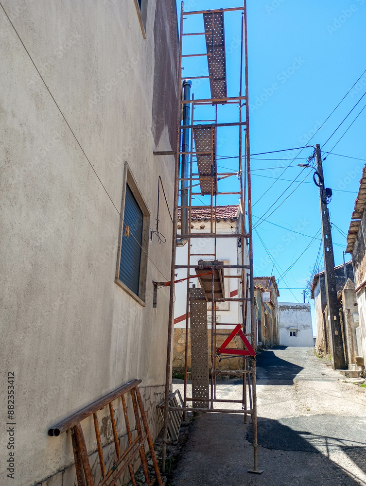 Construction scaffolding next to a building undergoing maintenance Construction scaffolding next to a building undergoing maintenance