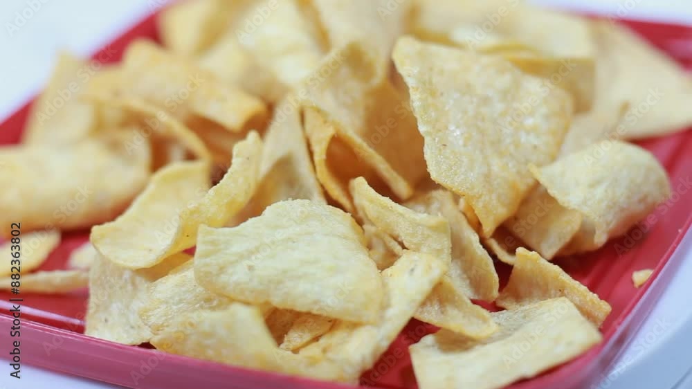 Spicy crackers on red plastic plate. Snacks move with a rotating display. Studio footage of delicious snacks Spicy crackers on red plastic plate. Snacks move with a rotating display. Studio footage of delicious snacks