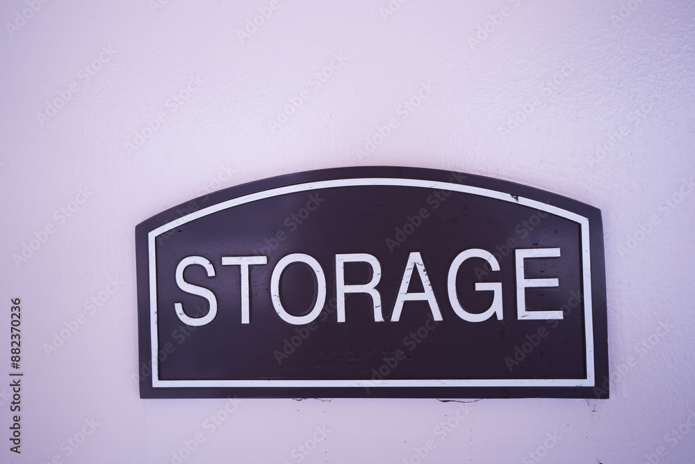 blue storage sign with white letters on a light colored wall, copy space available blue storage sign with white letters on a light colored wall, copy space available