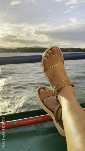 sailing on lake cocibolca in the city Granada, in Nicaragua, feet in the foreground leaning on the boat's railing, slow motion photo