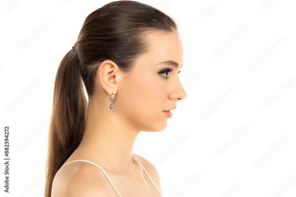 profile of a young serious teenage girl witht makeup and tied hair on a white background profile of a young serious teenage girl witht makeup and tied hair on a white background