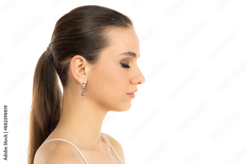 profile of a young serious teenage girl witht makeup closed eyes and tied hair on a white background profile of a young serious teenage girl witht makeup closed eyes and tied hair on a white background