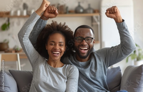 Excited Couple Celebrating a Victory on the Couch at Home