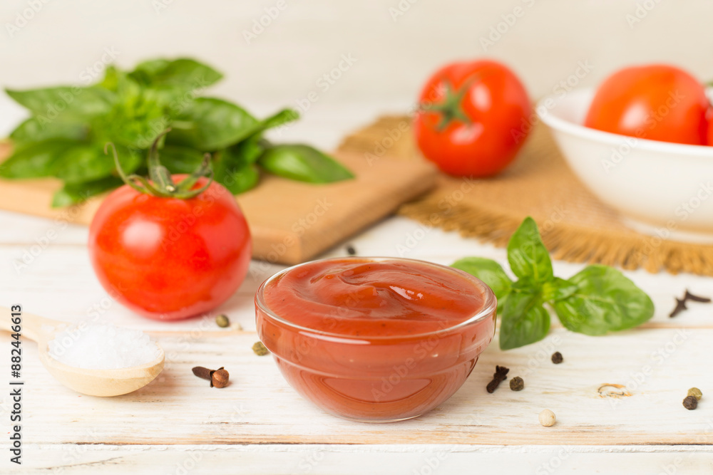 Delicious ketchup with spices and tomatoes on wooden table Delicious ketchup with spices and tomatoes on wooden table
