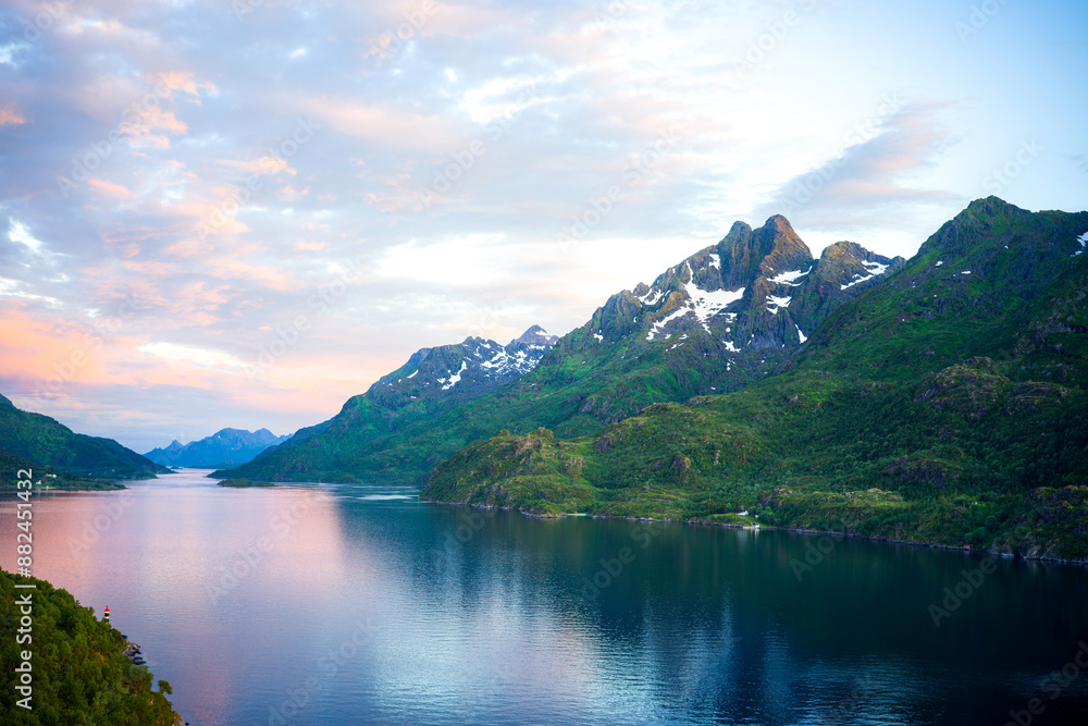 Naklejka premium Lofoten, Norway - July 2024: Beautiful fjord scenery with reflections in the water and vibrant colors. Entrance to the island area of outstanding natural beauty. Mountain and forest scenery with lake 