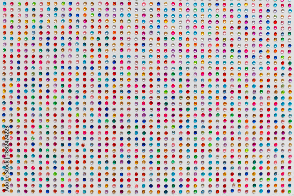 Multicolored rhinestones close-up on a white background. Preparation for the holiday. Children's handicrafts as a way of development and relaxation. Multicolored rhinestones close-up on a white background. Preparation for the holiday. Children's handicrafts as a way of development and relaxation.