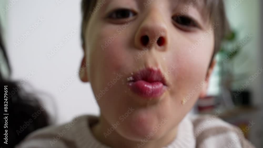 Boy takes a big bite of a pink frosted donut with colorful sprinkles, representing childhood indulgence and excitement, close-up of his mouth and hands, indoors Boy takes a big bite of a pink frosted donut with colorful sprinkles, representing childhood indulgence and excitement, close-up of his mouth and hands, indoors