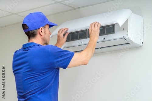 HVAC technician performing air conditioner maintenance inspection. Breakdowns repair service. Home insurance.