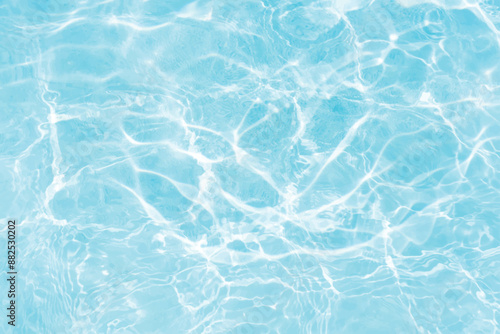 Blue water with ripples on the surface. Defocus blurred transparent blue colored clear calm water surface texture with splashes and bubbles. Water waves with shining pattern texture background.