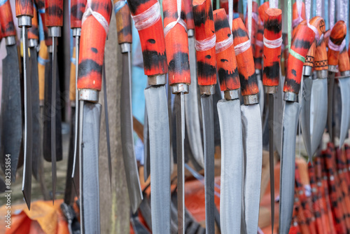 row of machete weapons hanging in a sharp weapons souvenir shop in Indonesia.wallapper background of traditional weapons photo