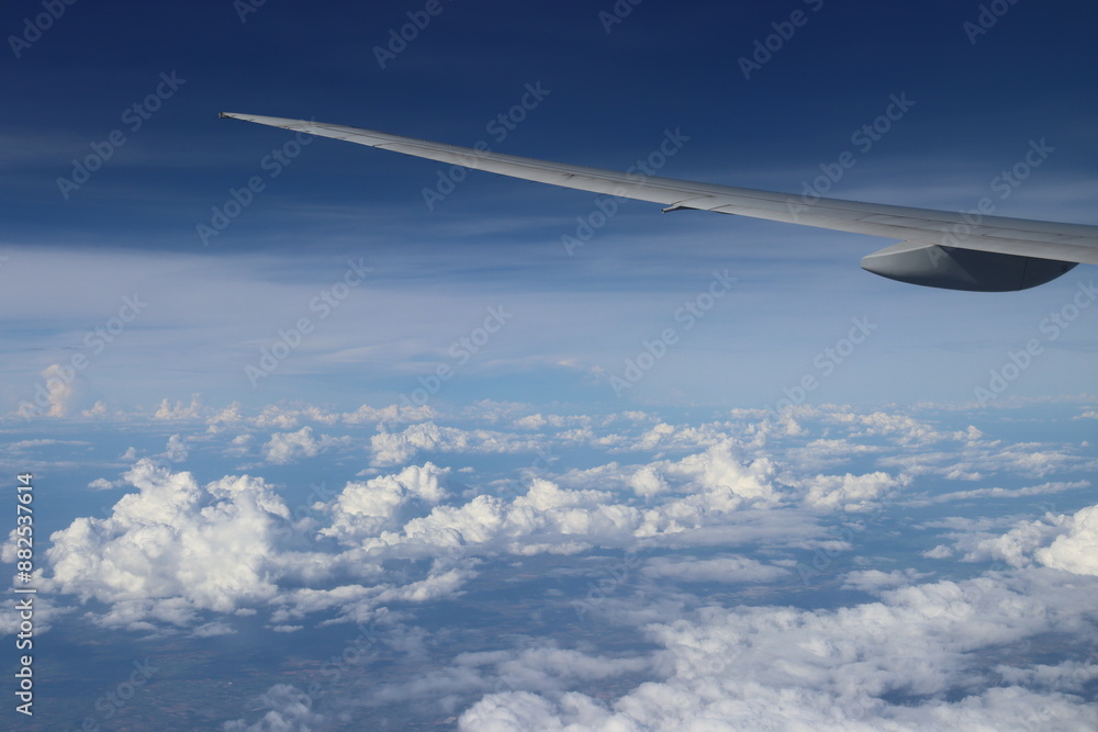 Aerial View of Urban Landscape with Airplane Wing Under Clear Blue Sky and Scattered Clouds Aerial View of Urban Landscape with Airplane Wing Under Clear Blue Sky and Scattered Clouds