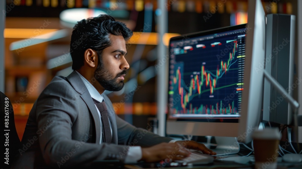 Financial securities traders, both male and female, working on desktop computers in a modern office. Handsome Indian accountant smiling happily while doing business financial accounting Financial securities traders, both male and female, working on desktop computers in a modern office. Handsome Indian accountant smiling happily while doing business financial accounting