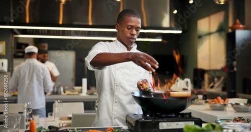 Obraz na płótnie Black man, chef and seasoning with frying pan in kitchen at restaurant for fine dining, meal and creativity