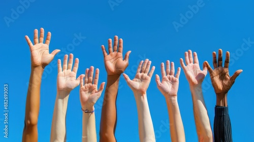 Hands of people from various nationalities raised above the sky, symbolizing equality. their right to express themselves freely and be heard.concept of democracy, agreement, and expressing opinions.