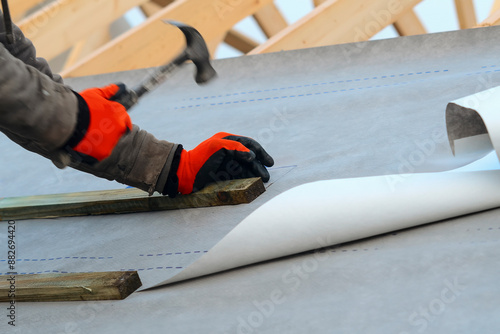 Tableau sur toile Construction Worker Installing Underlayment on Roof