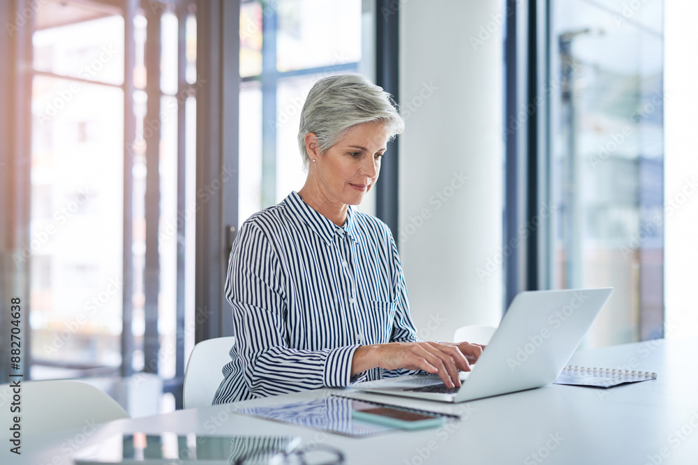 Woman, documents and desk with laptop in office for investment, feedback or reading finance news. Mature financial advisor, paper and typing with tech for foreign exchange, update or report to client Woman, documents and desk with laptop in office for investment, feedback or reading finance news. Mature financial advisor, paper and typing with tech for foreign exchange, update or report to client