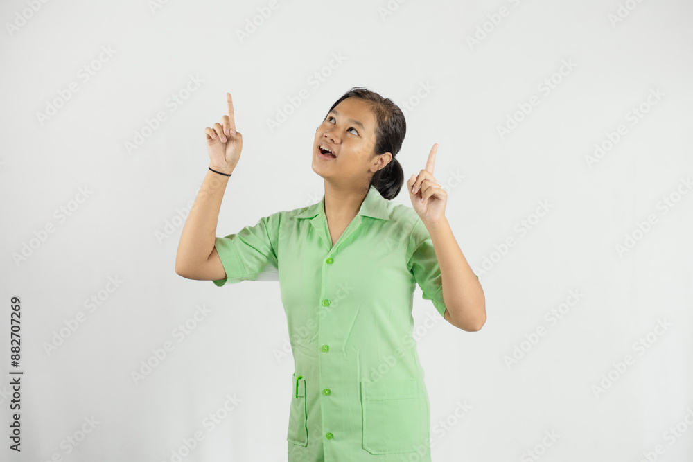 a young Asian nurse pointing her two fingers up with a happy expression and wears a green shirt, isolated on a white background
a young Asian nurse pointing her two fingers up with a happy expression and wears a green shirt, isolated on a white background